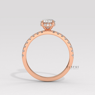 Low-angle view of a oval cut moissanite engagement ring with a hidden halo and half pave band