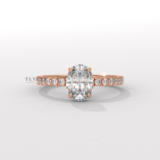 Oval cut moissanite engagement ring with a hidden halo and half pave band photographed on a white background