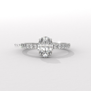 Angled view of a oval cut moissanite engagement ring with a hidden halo and half pave band catching the light