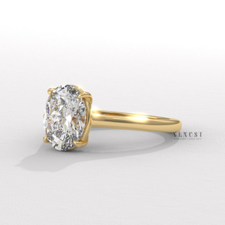 Oval cut moissanite engagement ring in a hidden halo solitaire setting photographed on a white background