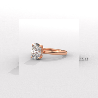 Front view of a oval cut moissanite engagement ring in a hidden halo solitaire setting with the band in focus