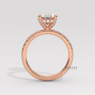 Oval cut moissanite engagement ring with a pave band photographed on a white background