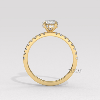 Centre-stone close-up of a oval cut moissanite engagement ring with a hidden halo and half pave band