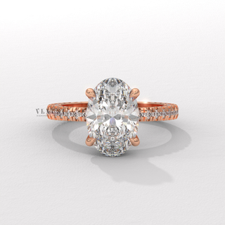 Low-angle view of a oval cut moissanite engagement ring with a hidden halo and pave band