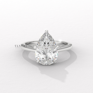 Overhead close-up of a pear cut moissanite engagement ring with a hidden halo and cathedral setting