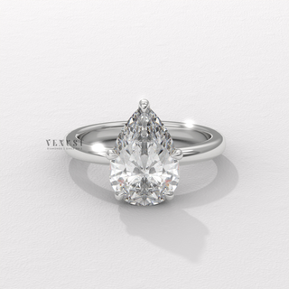 Angled view of a pear cut moissanite engagement ring in a hidden halo solitaire setting catching the light