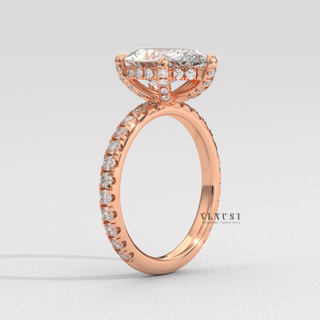 Close-up of a pear cut moissanite engagement ring with a pave band
