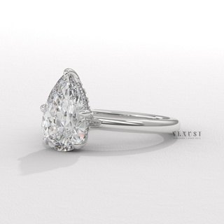 Tilted view of a pear cut moissanite engagement ring in a hidden halo solitaire setting showing its sparkle
