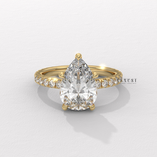 Low-angle view of a pear cut moissanite engagement ring with a pave band