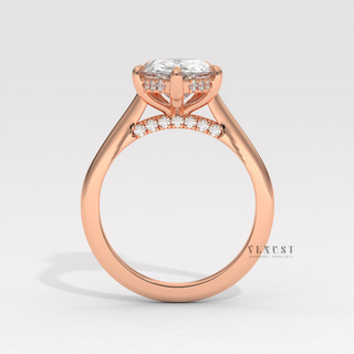 Profile shot of a pear cut moissanite engagement ring with a hidden halo and cathedral setting and its band