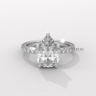 Profile shot of a pear cut moissanite engagement ring with a pave band and its band