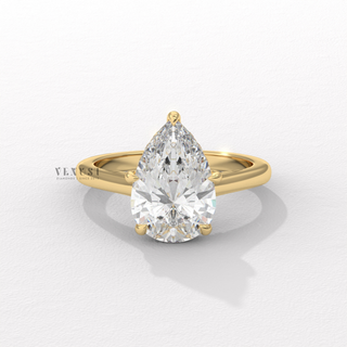Angled view of a pear cut moissanite engagement ring with a hidden halo and cathedral setting catching the light