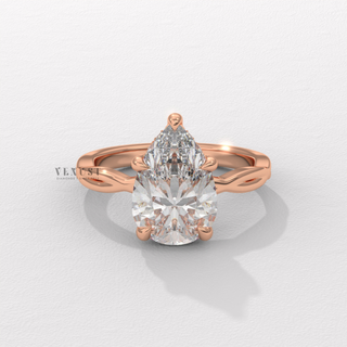Centre-stone close-up of a pear cut moissanite engagement ring on an infinity band
