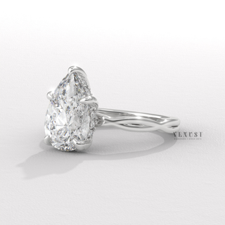 Front view of a pear cut moissanite engagement ring on an infinity band
