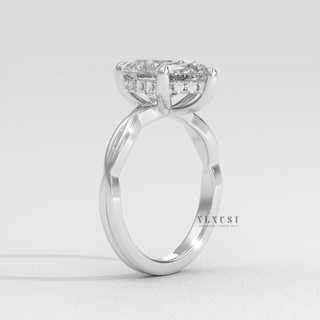 Close-up of a pear cut moissanite engagement ring on an infinity band