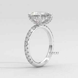Three-quarter angle of a pear cut moissanite engagement ring with a pave band