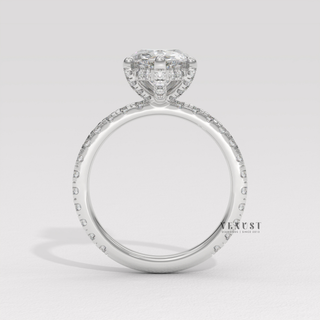 Pear cut moissanite engagement ring with a pave band photographed on a white background