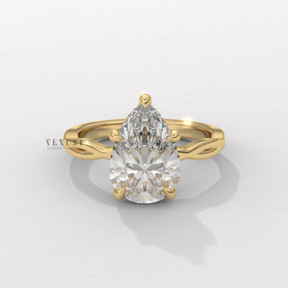 Low-angle view of a pear cut moissanite engagement ring on an infinity band