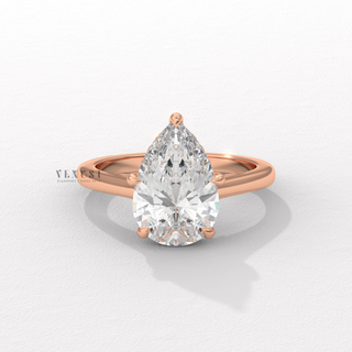 Pear cut moissanite engagement ring with a hidden halo and cathedral setting shown on a finger