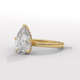 Overhead close-up of a pear cut moissanite engagement ring in a hidden halo solitaire setting