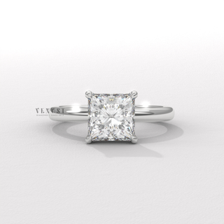 Princess cut moissanite engagement ring in a hidden halo solitaire setting photographed on a white background