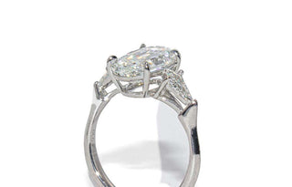 Oval step cut three stone moissanite engagement ring angled sparkle view