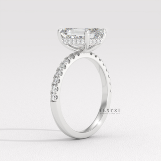 Angled view of a emerald cut moissanite engagement ring with a hidden halo and pave band catching the light