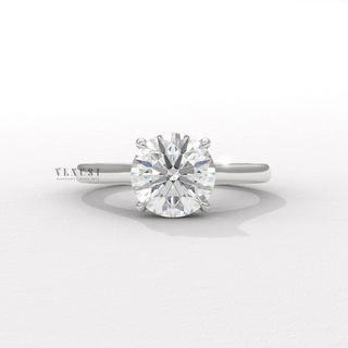 Tilted view of a round cut moissanite engagement ring with a hidden halo and cathedral setting showing its sparkle