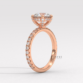 Round cut moissanite engagement ring with a hidden halo and pave band worn on a hand