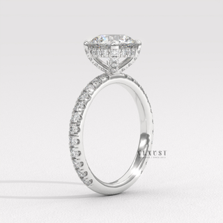 Round cut moissanite engagement ring with a hidden halo and pave band photographed on a white background