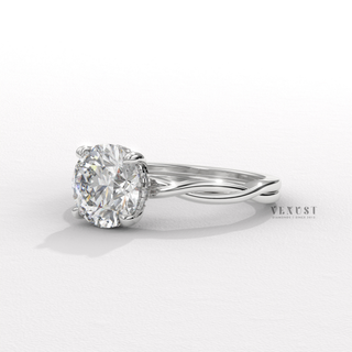 Top-down view of a round cut moissanite engagement ring on an infinity band