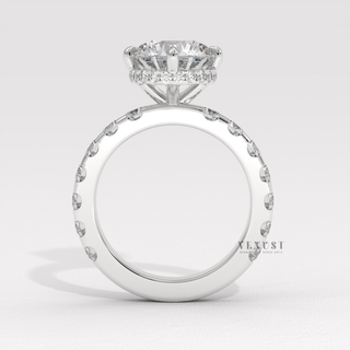 Front view of a round cut moissanite engagement ring with a hidden halo and pave band under bright light