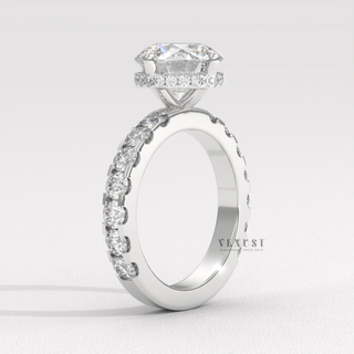 Front view of a round cut moissanite engagement ring with a hidden halo and pave band from the left