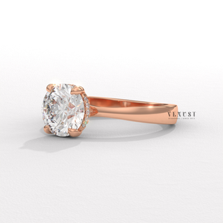 Studio shot of a round cut moissanite engagement ring in a hidden halo solitaire setting on a plain backdrop