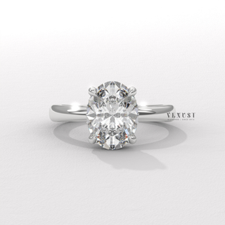 Tilted view of a oval cut moissanite engagement ring in a hidden halo solitaire setting showing its sparkle