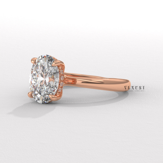 Hand model wearing a oval cut moissanite engagement ring in a hidden halo solitaire setting
