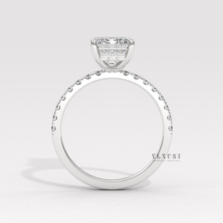 Tilted view of a emerald cut moissanite engagement ring with a hidden halo and pave band showing its sparkle