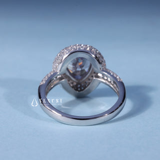 Angled view of Pear Cut Bezel Moissanite Halo Engagement Ring with Pave