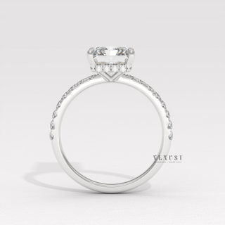 Front view of a radiant cut moissanite engagement ring with a pave band under bright light