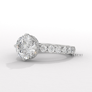 Low-angle view of a round cut moissanite engagement ring with a hidden halo and pave band