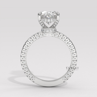 Front view of a oval cut moissanite engagement ring with a hidden halo and pave band under bright light